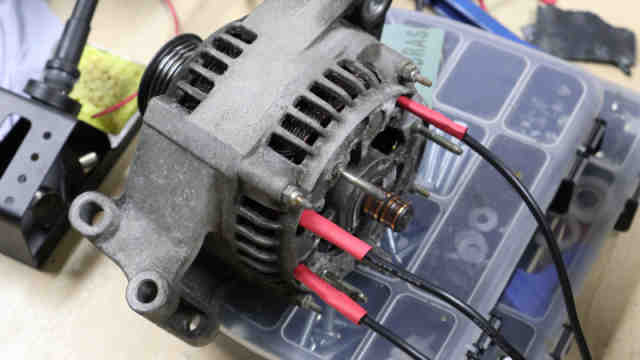 How fast does a car alternator need to spin to produce power?